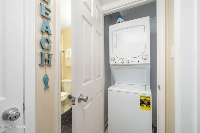 laundry room with tile patterned floors and stacked washer / dryer