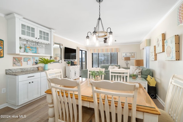 dining space with crown molding, a wealth of natural light, and light hardwood / wood-style flooring