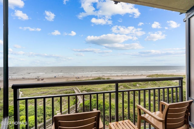 balcony featuring a water view and a beach view