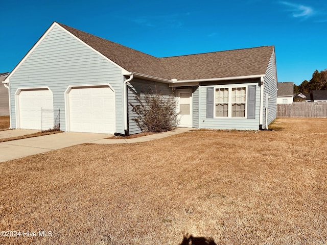 ranch-style home with a garage and a front lawn