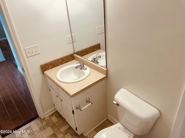 bathroom featuring wood-type flooring, vanity, and toilet