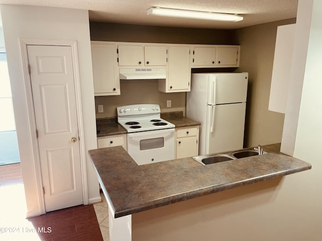 kitchen featuring kitchen peninsula, a textured ceiling, white appliances, and sink