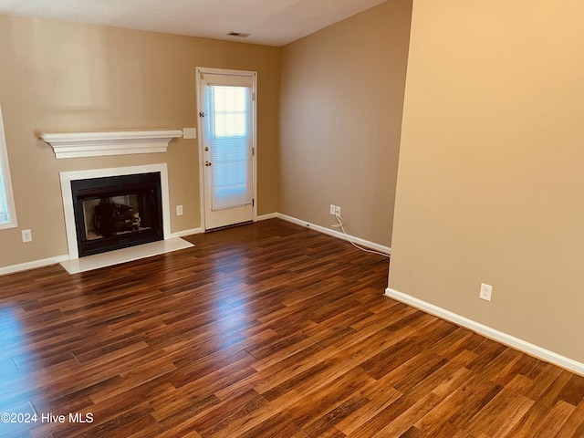 unfurnished living room featuring dark hardwood / wood-style floors