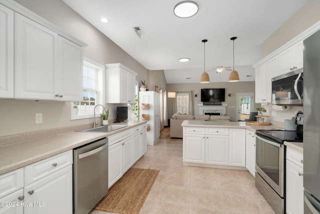 kitchen featuring sink, stainless steel appliances, white cabinets, lofted ceiling, and light tile patterned flooring