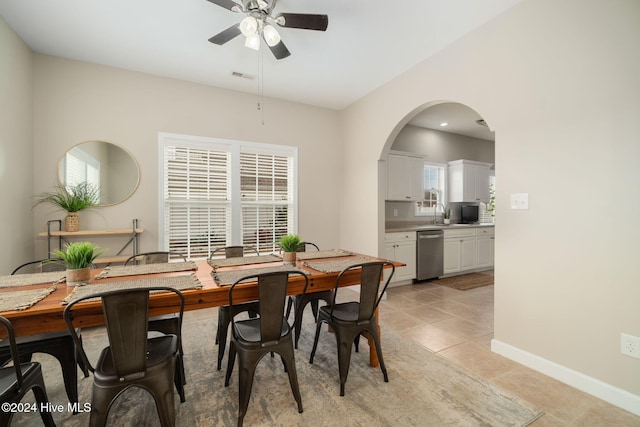 tiled dining room with ceiling fan and sink