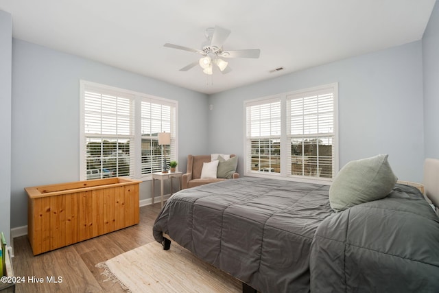 bedroom featuring multiple windows, light wood-type flooring, and ceiling fan