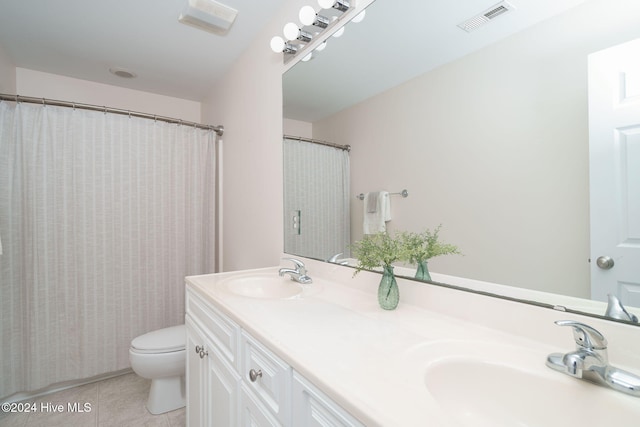 bathroom with tile patterned floors, vanity, and toilet