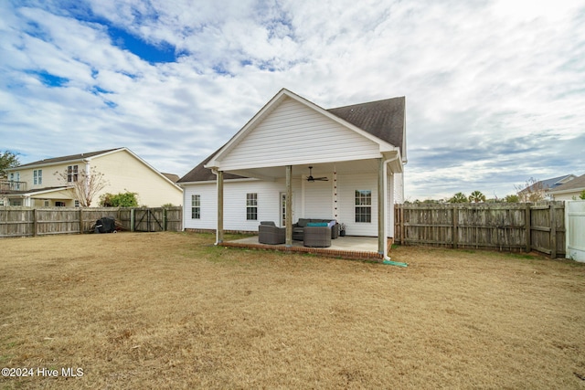 back of house featuring outdoor lounge area, a yard, ceiling fan, and a patio area