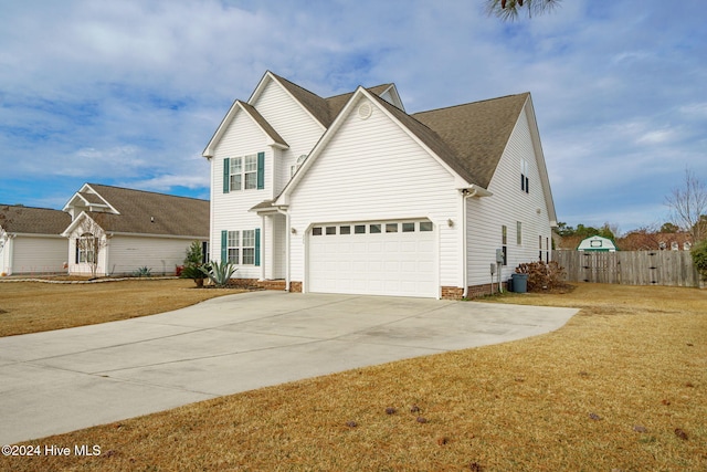 view of property featuring a garage and a front yard