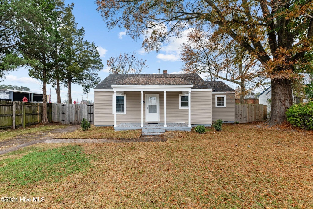 bungalow-style home with a front lawn and covered porch