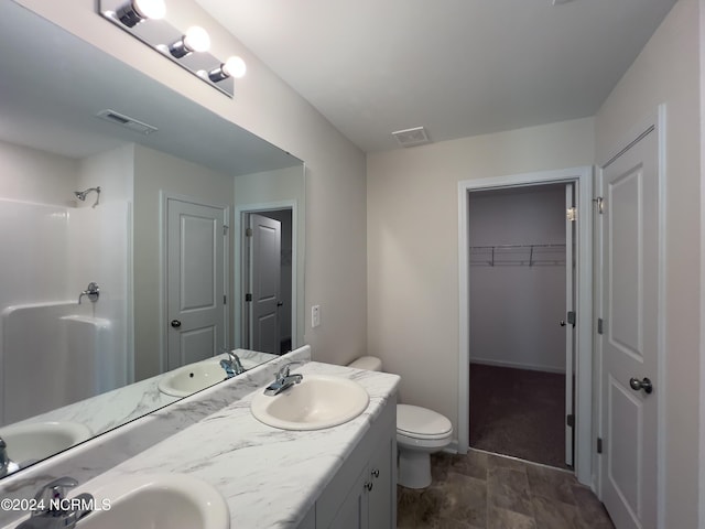 bathroom featuring vanity, toilet, and a shower