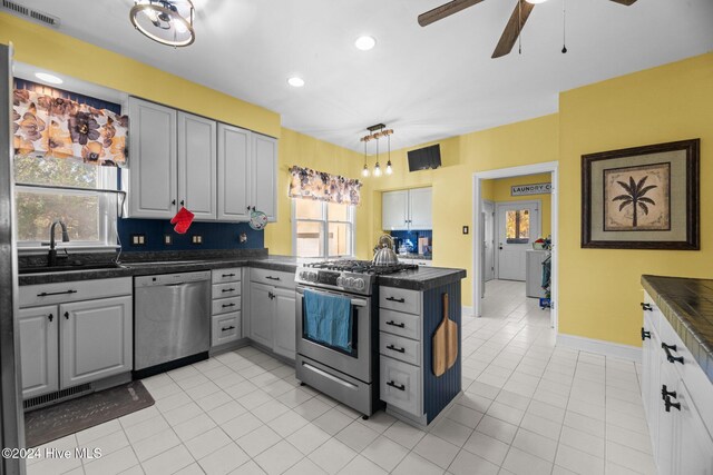 kitchen with tasteful backsplash, white cabinets, and appliances with stainless steel finishes