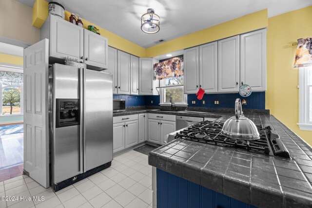 kitchen featuring light tile patterned floors, tasteful backsplash, and hanging light fixtures