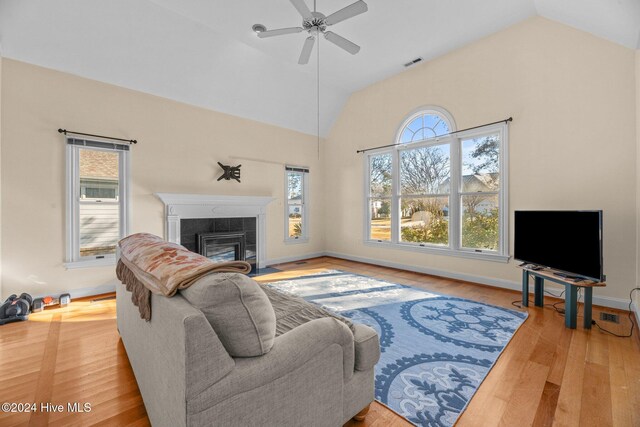 unfurnished dining area featuring a fireplace, ceiling fan, and light hardwood / wood-style flooring