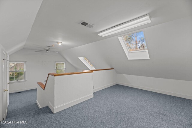 stairs with vaulted ceiling with skylight, carpet floors, and a healthy amount of sunlight