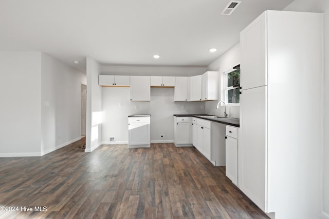 kitchen with dark hardwood / wood-style floors, white cabinetry, and sink