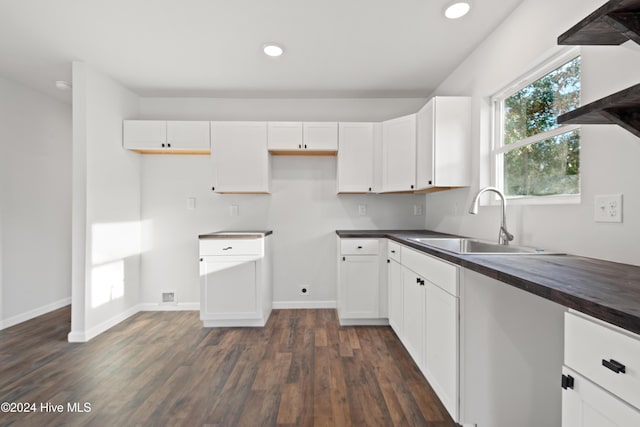 kitchen featuring dark hardwood / wood-style floors, white cabinetry, butcher block counters, and sink