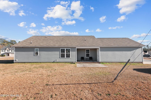 rear view of property with a lawn and a patio area