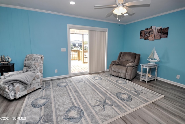 sitting room featuring hardwood / wood-style floors, ceiling fan, and crown molding