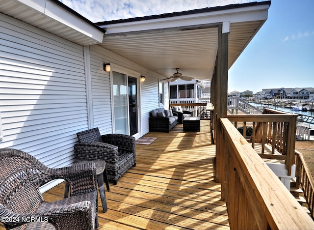 wooden deck with ceiling fan and a water view