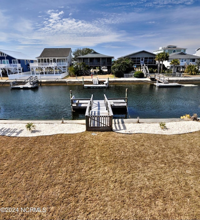 dock area with a water view and a lawn