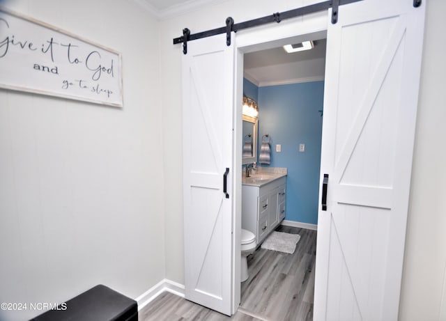 bathroom featuring crown molding, toilet, vanity, and hardwood / wood-style flooring