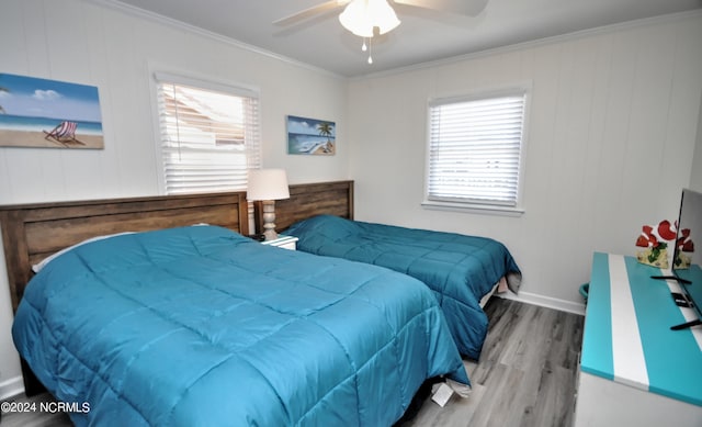 bedroom featuring hardwood / wood-style flooring, ceiling fan, and crown molding