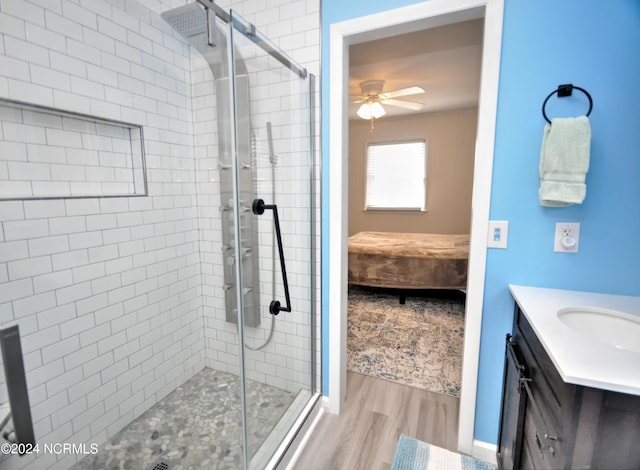 bathroom featuring hardwood / wood-style flooring, vanity, ceiling fan, and walk in shower