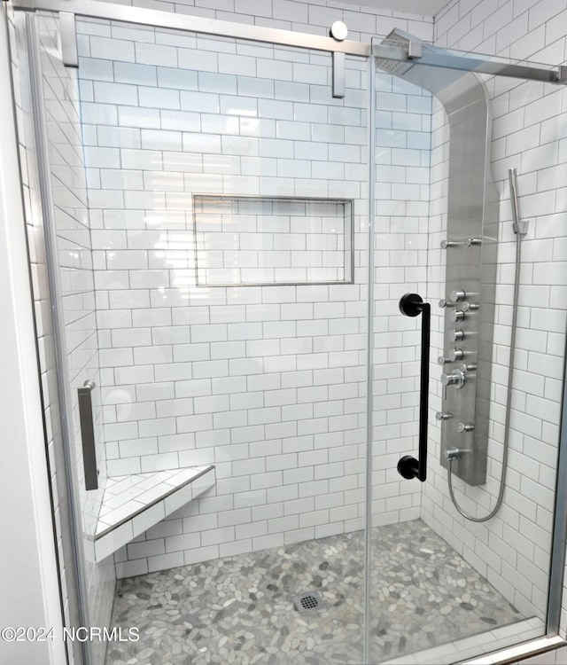 bathroom featuring a shower with shower door