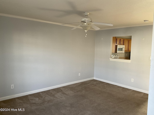 unfurnished room featuring dark colored carpet, ceiling fan, and crown molding