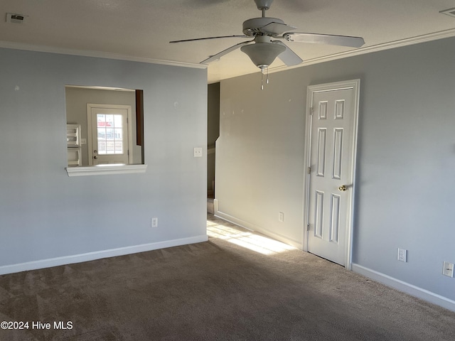 carpeted spare room with ceiling fan and ornamental molding