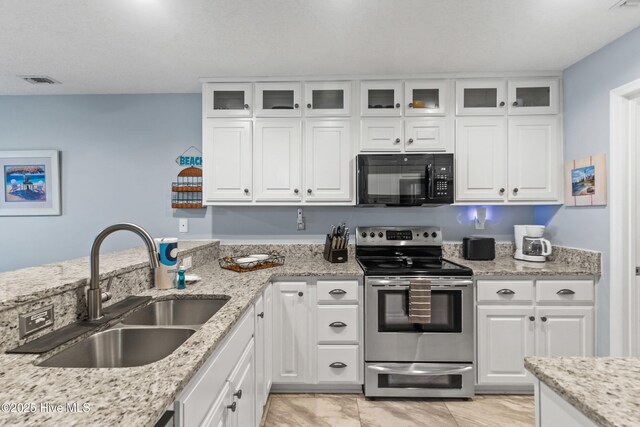 kitchen with separate washer and dryer, a kitchen breakfast bar, stainless steel appliances, kitchen peninsula, and white cabinets