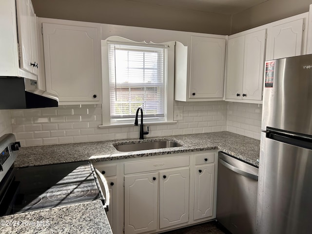 kitchen featuring backsplash, exhaust hood, white cabinets, sink, and appliances with stainless steel finishes