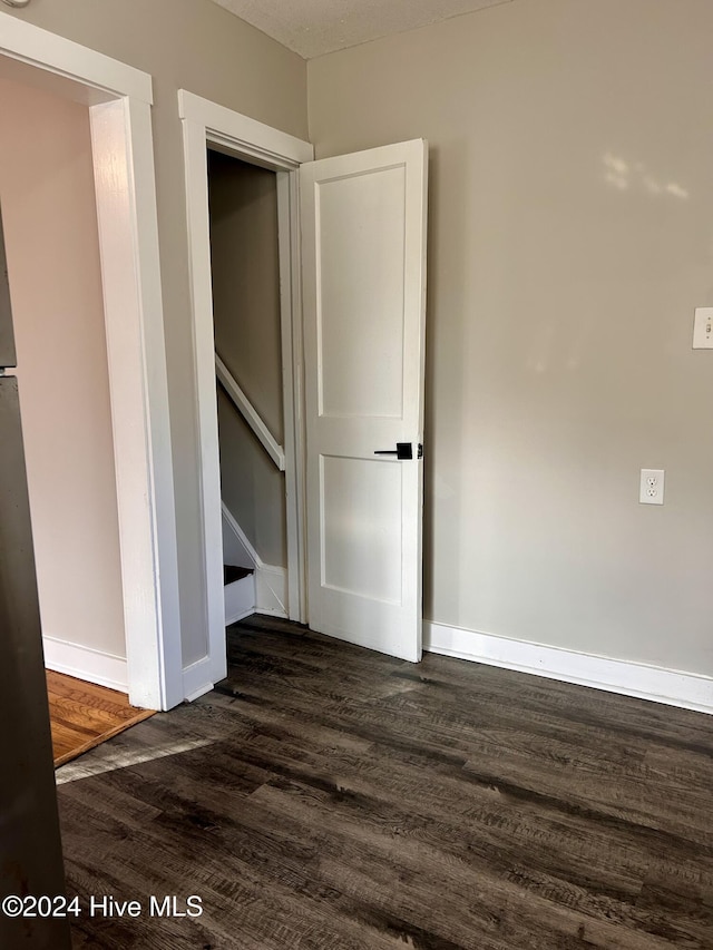 spare room featuring dark wood-type flooring