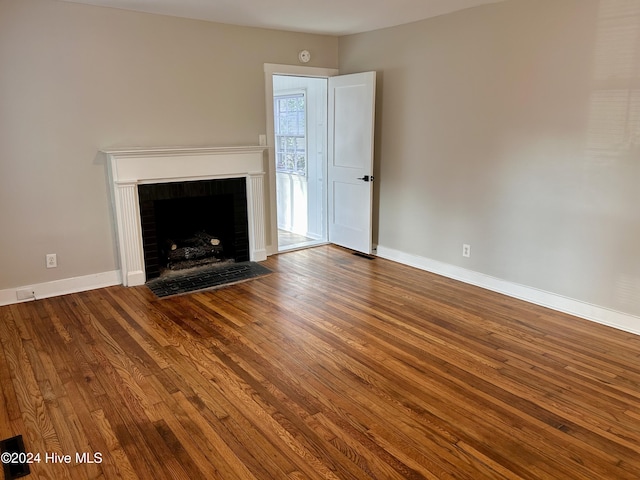 unfurnished living room featuring a fireplace and hardwood / wood-style flooring