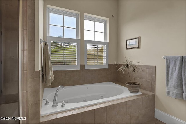 bathroom with a relaxing tiled tub