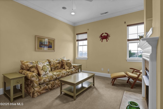 carpeted living room with crown molding and ceiling fan