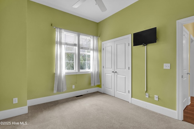 unfurnished bedroom with carpet flooring, ceiling fan, and a closet