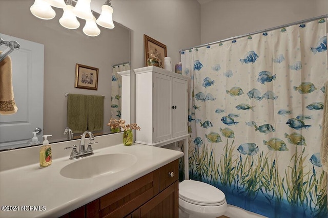 bathroom featuring a notable chandelier, toilet, walk in shower, and vanity