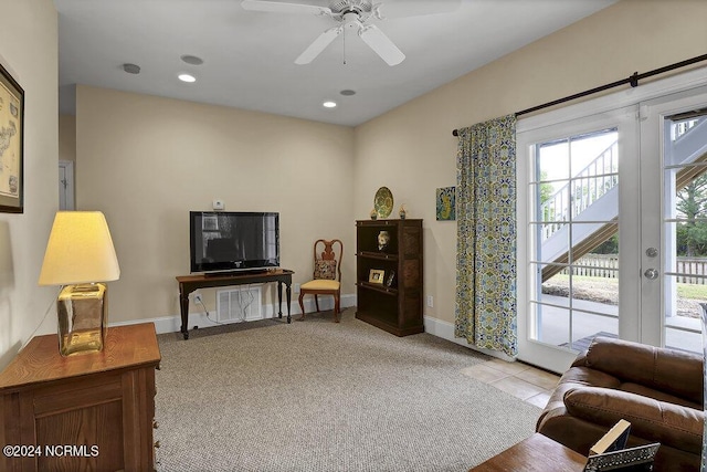 living room with light carpet, french doors, and ceiling fan