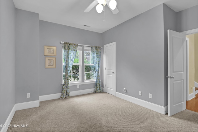 carpeted spare room featuring ceiling fan