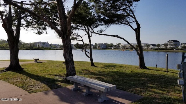 surrounding community featuring a lawn and a water view