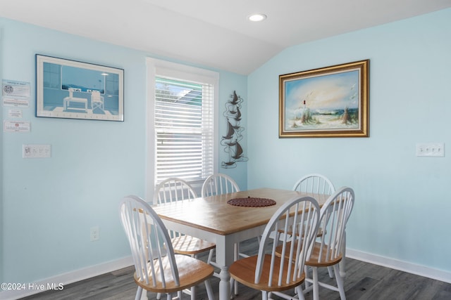 dining room with lofted ceiling and dark wood-type flooring