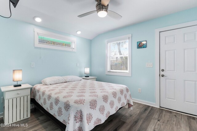 bedroom featuring dark hardwood / wood-style floors, vaulted ceiling, and ceiling fan