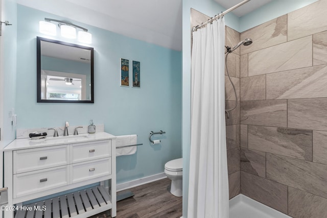 bathroom featuring a shower with shower curtain, wood-type flooring, vanity, and toilet