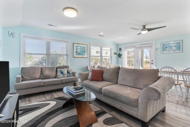 living room with light hardwood / wood-style floors, ceiling fan, and lofted ceiling