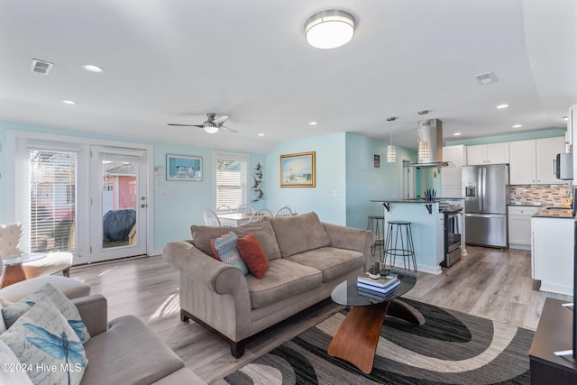 living room with ceiling fan and light hardwood / wood-style floors