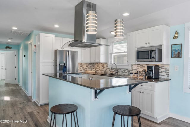 kitchen featuring a breakfast bar, sink, stainless steel fridge with ice dispenser, white cabinetry, and island exhaust hood