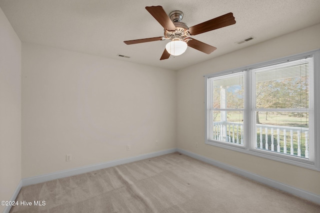 unfurnished room featuring light carpet, a textured ceiling, and ceiling fan