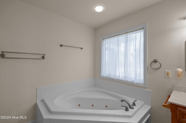 bathroom featuring vanity and a relaxing tiled tub